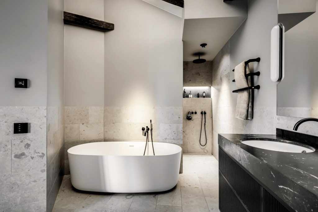 A two-toned bathroom made with different stones, paired with black bathroom fixtures