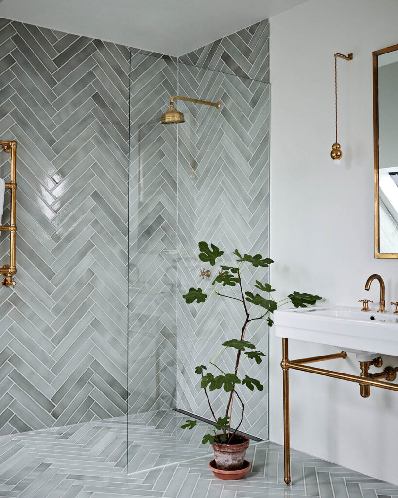 A marbled Herringbone Pattern on the Bathroom Floor and Shower Walls