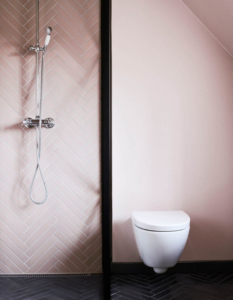 Pink herringbone walls paired with pink wall paint in a modern bathroom