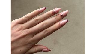 A close up of Digital Beauty Writer, Sennen Prickett's burgundy and pink chrome bow and French tip nails