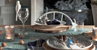 Close up detail of a dining table style with white doves and blue decorations for Christmas