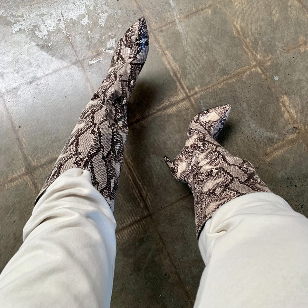 Snake-print Chinese Laundry boots styled with white pants