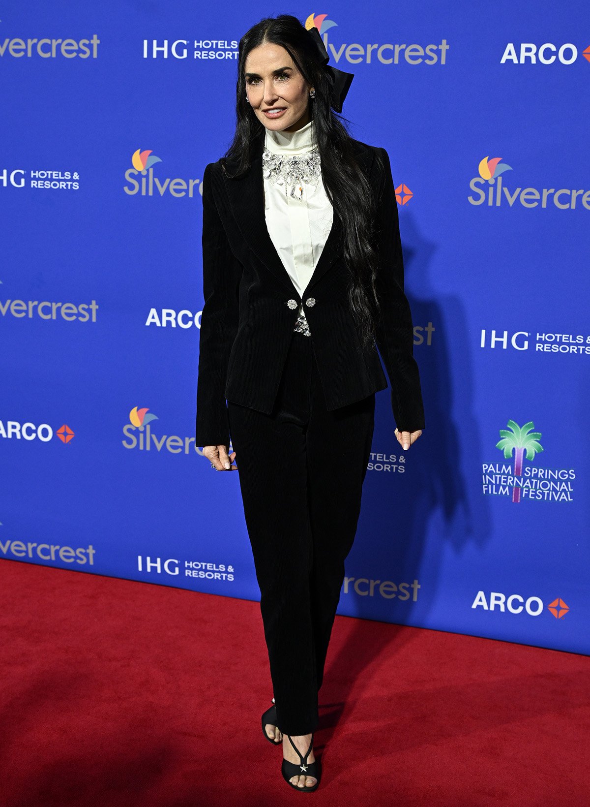 Demi Moore attends the 36th Annual Palm Springs International Film Awards at Palm Springs Convention Centre in a black velvet Chanel suit with a white turtleneck blouse