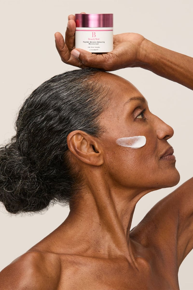 A model holding a cream above her head