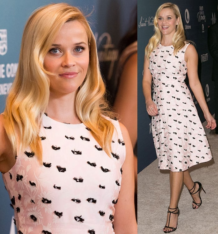 Reese Witherspoon looks effortlessly chic in a pastel pink dress with black floral accents paired with strappy black sandals