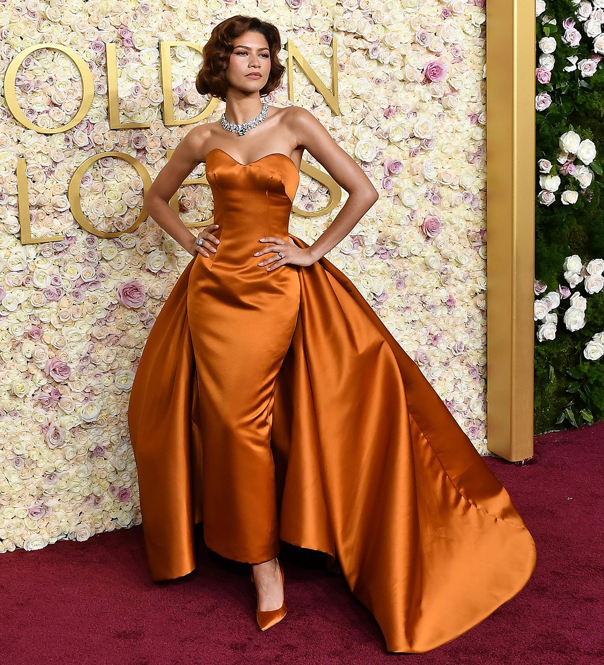 Newly engaged Zendaya stuns in a custom burnt orange Louis Vuitton strapless gown with an attached train