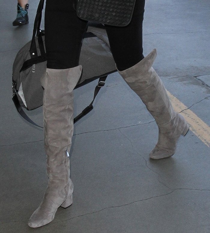 Kate Upton effortlessly elevates her airport style in chic gray suede Sam Edelman thigh-high boots